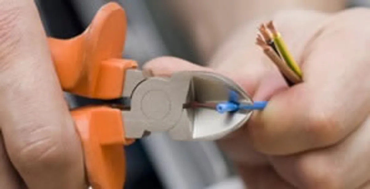 licensed electrician performing precise wire cutting and preparation during electrical service in Cambridge, MA
