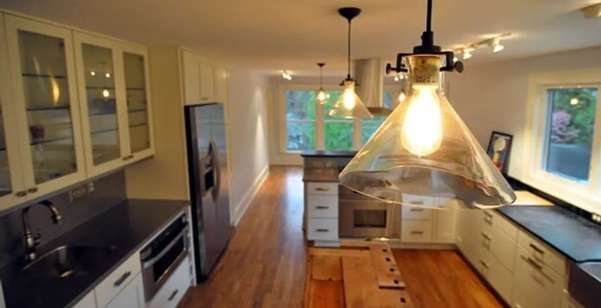 Residential electrician installing modern indoor light fixture in a home in Cambridge, MA